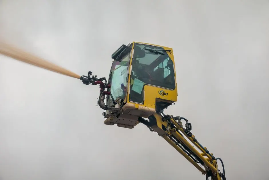 Close-up view of an aerial firefighting machine spraying water during a safety drill.