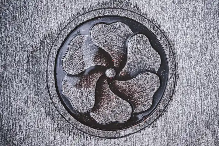 Top view of creative gray etching representing round plate with wavy plant leaves and rounded center floating on water